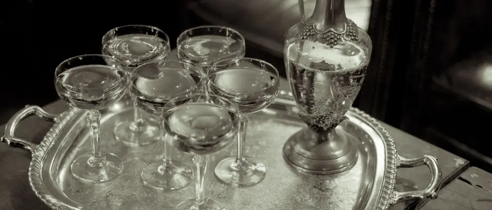 Crystal coupes and a silver claret jug on an engraved silver tray