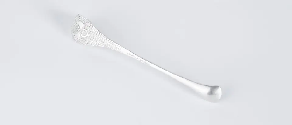 A single silver spoon with a pierced handle on a white ground