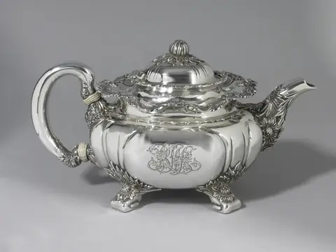 A sterling teapot by Tiffany & Co. in the Chrysanthemum pattern, with chased flowers on its spout, lid and feet